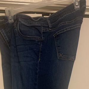 Dark blue jeans. Ankle length with ragged edges.